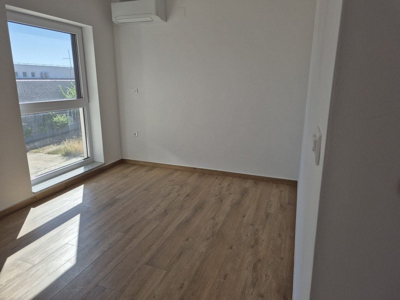 Ložnice s oknem a dřevěnou podlahou
