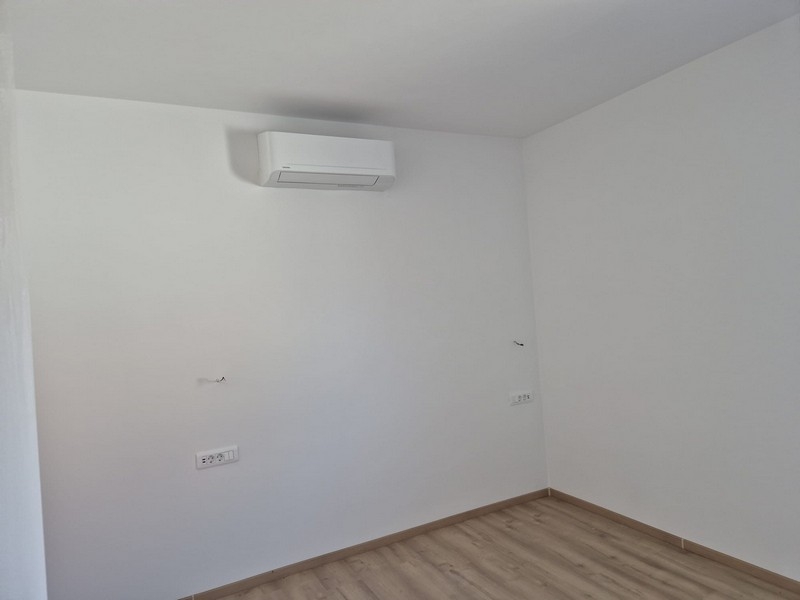 Pokoj s klimatizací a bílými stěnami