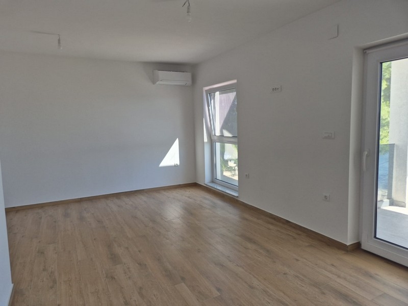 Obytná část penthouse s dřevěnou podlahou a oknem