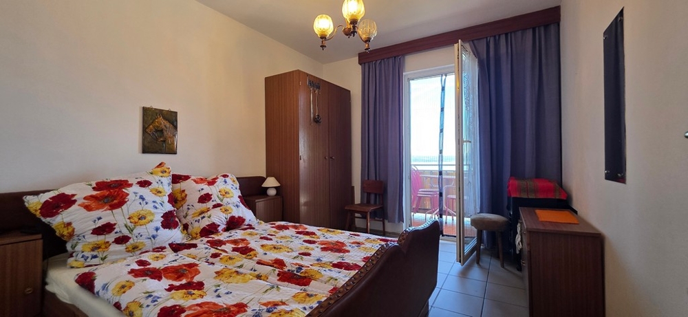 Ložnice s manželskou postelí a balkonovými dveřmi, apartmán A4103