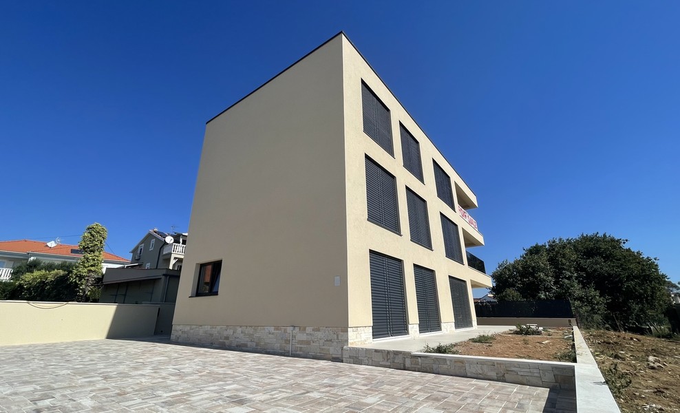 Boční pohled na budovu s dlážděným dvorem