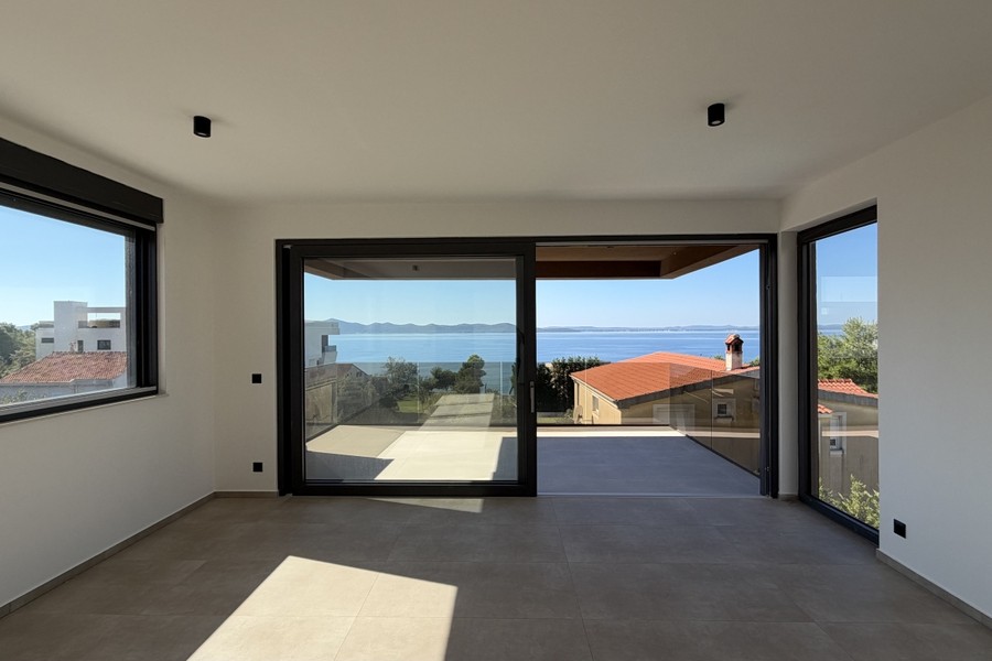 Obytná část s velkými okenními prosklenými stěnami na balkon