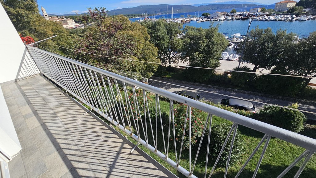 Dlouhý balkon se zábradlím nad ulicí