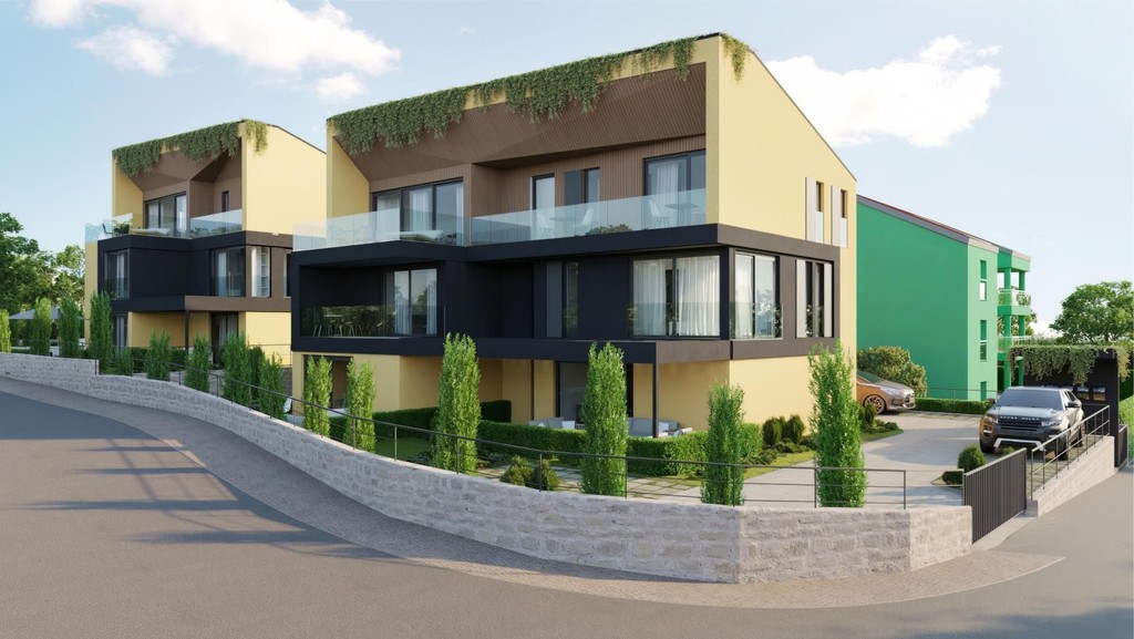 Novostavby se skleněnými balkony a zelenými okraji střech u ulice