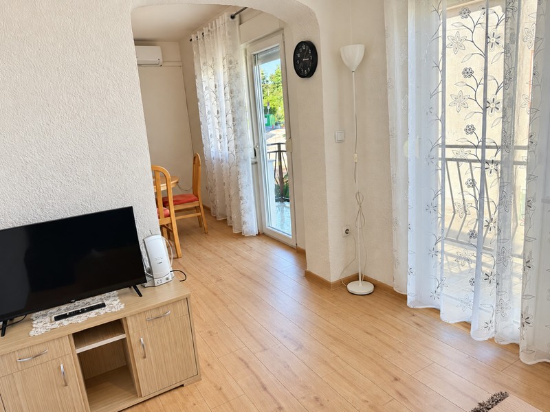 Obytná část s televizí a dveřmi na balkon