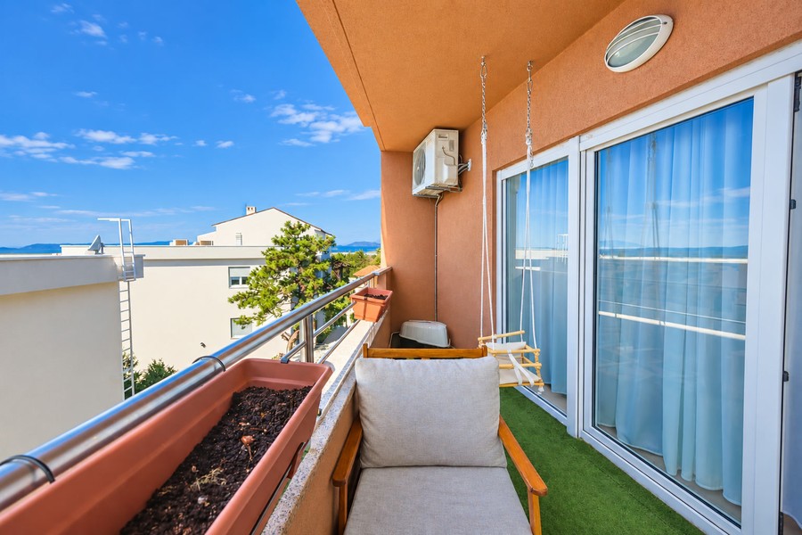 Balkon s křeslem a skleněnými dveřmi
