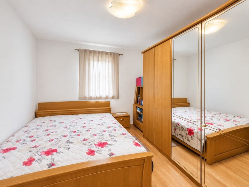 Ložnice s manželskou postelí a zrcadlovou skříní