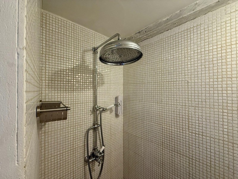 Pohled od umyvadla k okenici s vyraženým srdcem.