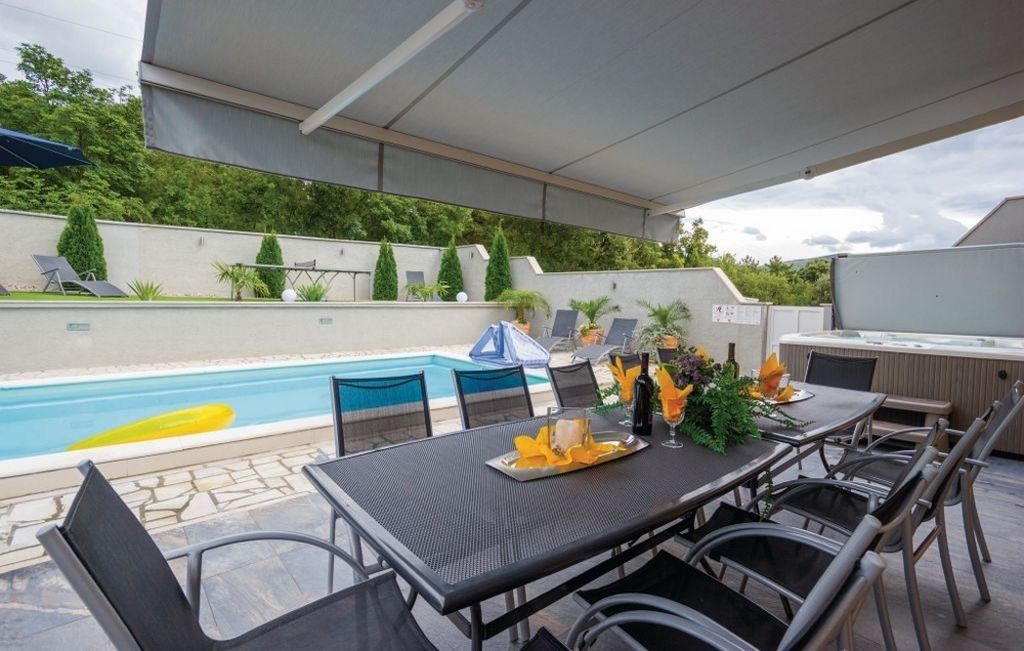 Terasa a bazén za domem s výhledem na přilehlý les.