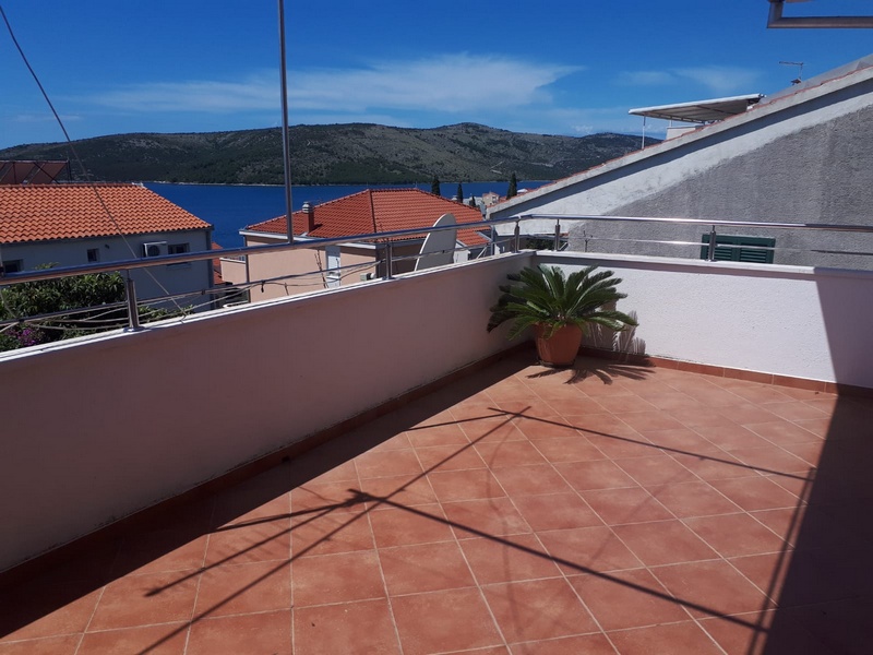 Obrázek kryté terasy se stolem a židlemi