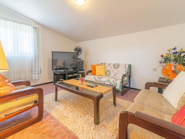 Pohled do obývacího pokoje s pohovkou a stolem v regionu Zadar.