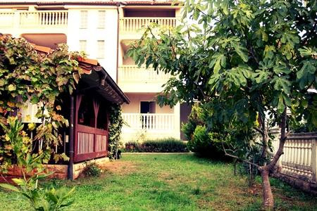 Zahrada domu s výhledem na zadní část domu s balkony.