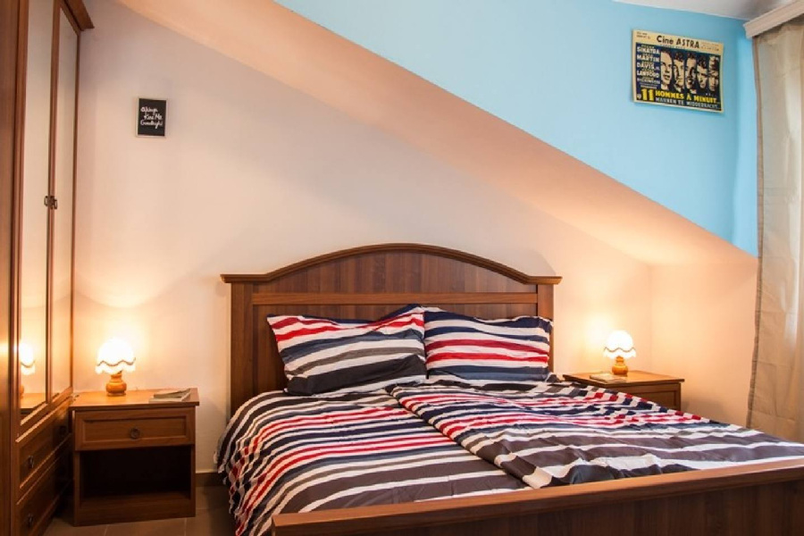 Podkrovní ložnice s manželskou postelí a oknem v regionu Pula.