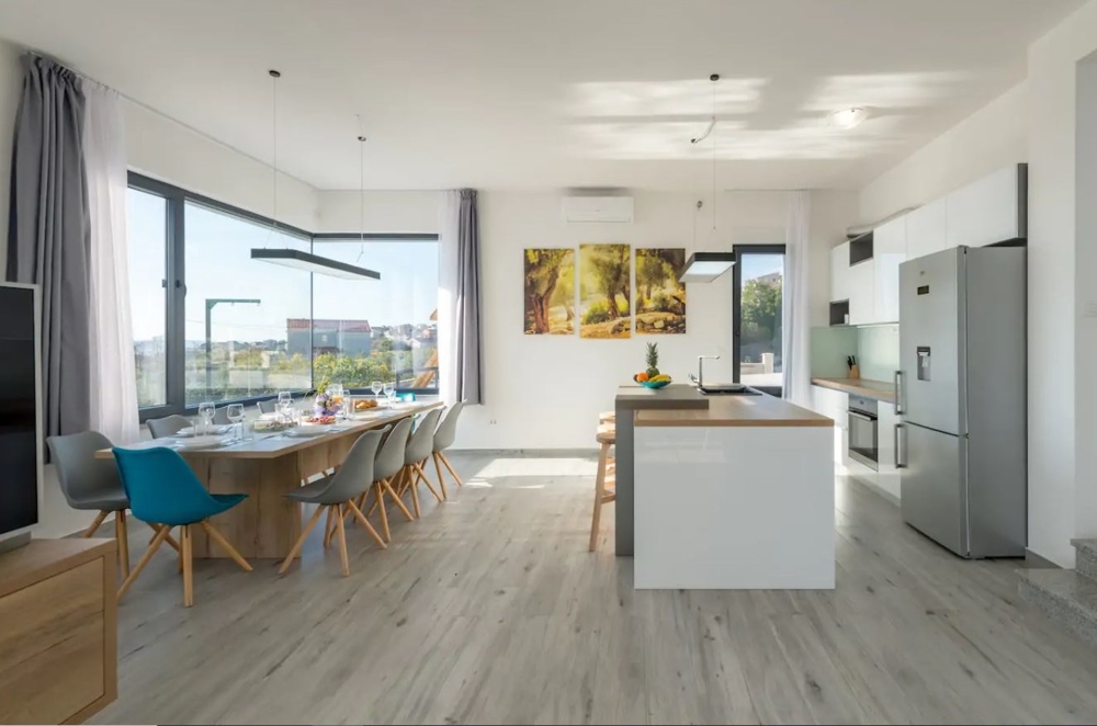 Moderní obývací pokoj s otevřenou kuchyní a jídelním koutem.