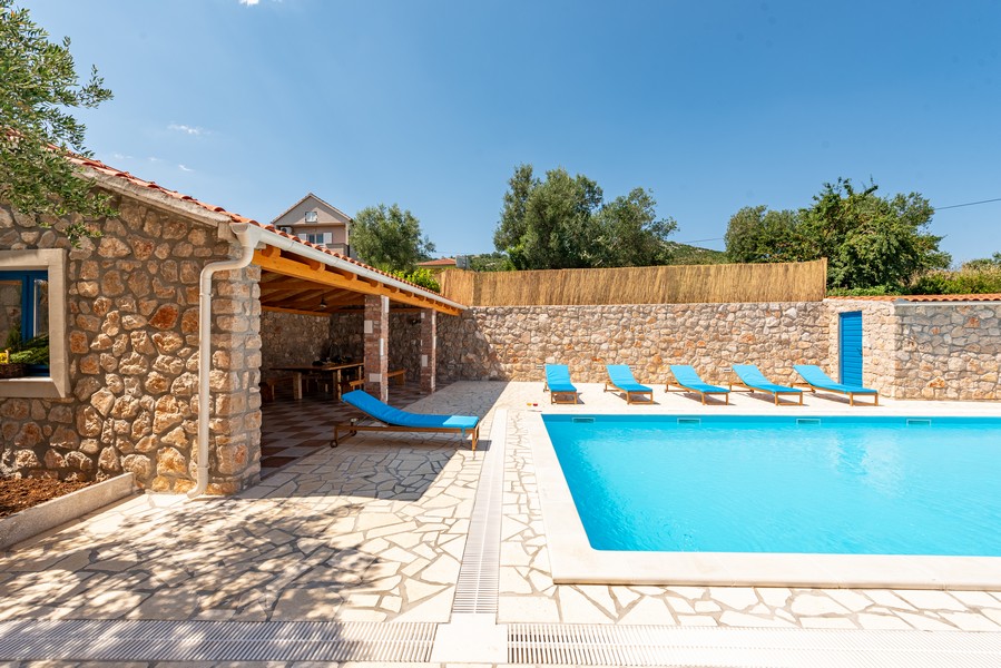 Kamenný dům s bazénem a prostorem na opalování