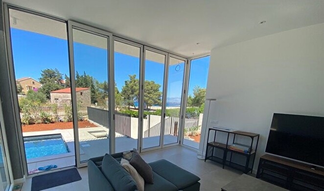 Obývací pokoj s výhledem na bazén.