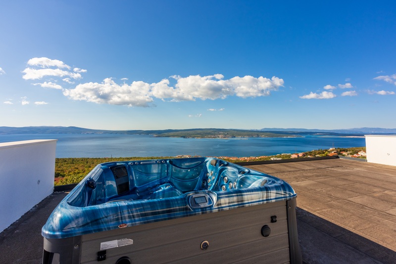 Střešní terasa s jacuzzi a panoramatickým výhledem na moře.
