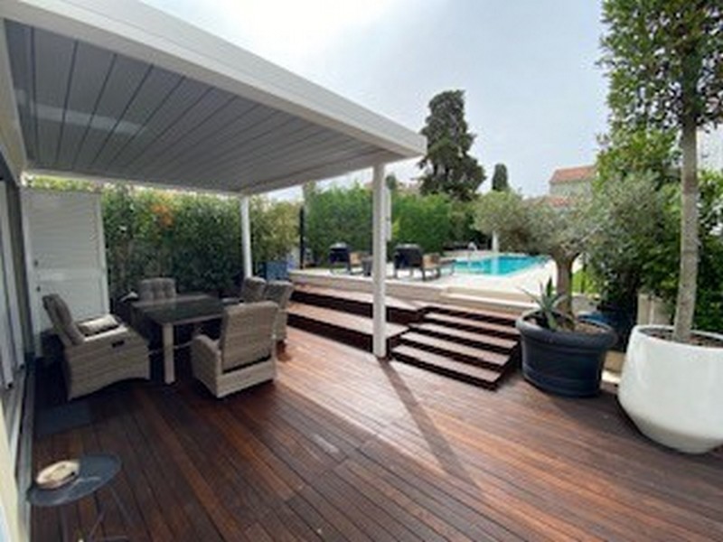 Polokrytá dřevěná terasa s výhledem na bazén luxusní vily na Istrii na prodej.