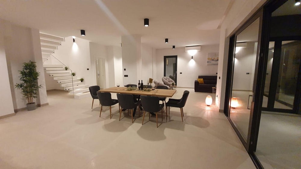 Otevřený prostor s jídelním stolem a výhledem na schodiště.