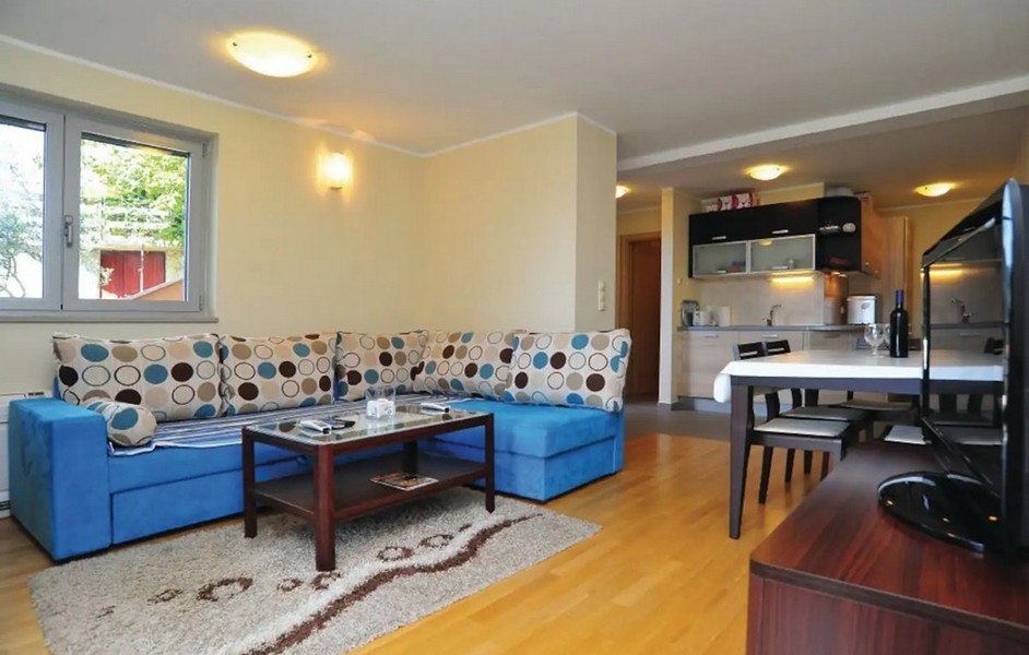 Obývací pokoj s modrým gaučem.