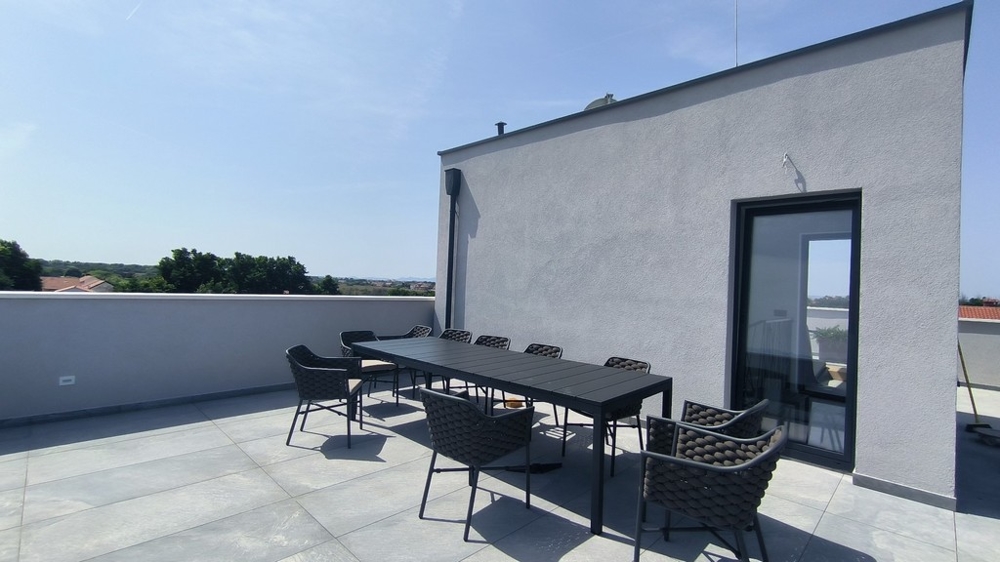 Střešní terasa s velkým jídelním stolem a výhledem