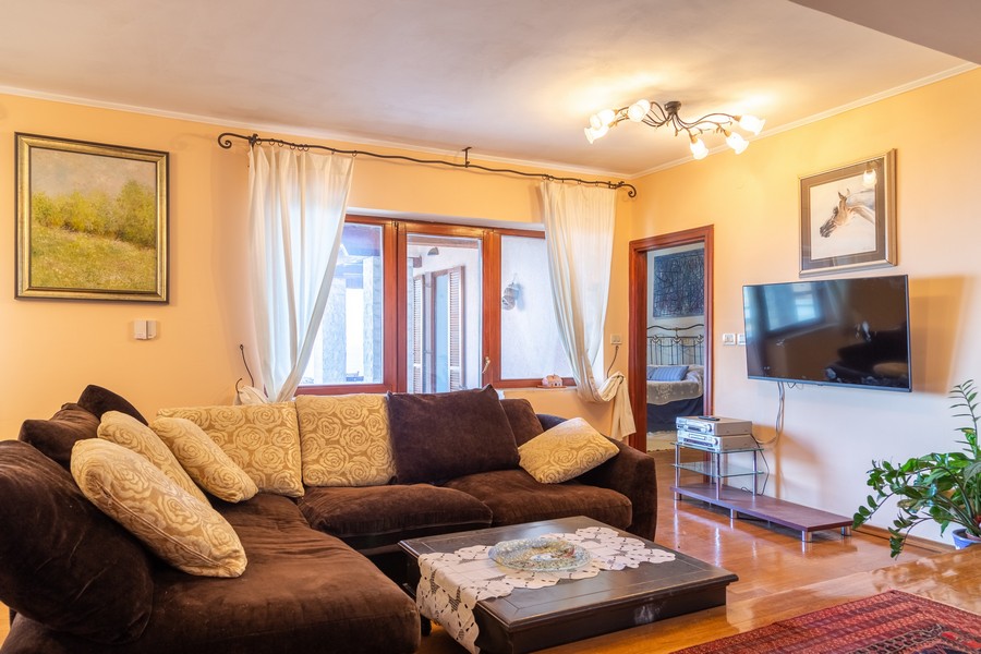 Pěkně zařízený obývací pokoj s chytrou televizí na stěně.