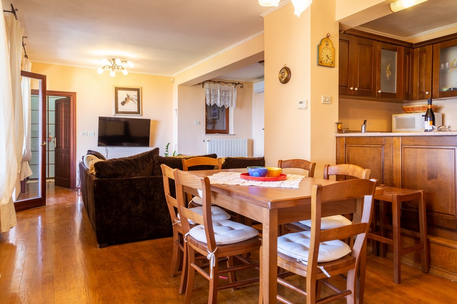 Jídelní kout a kuchyně ve venkovském stylu s třešňovým dřevem.