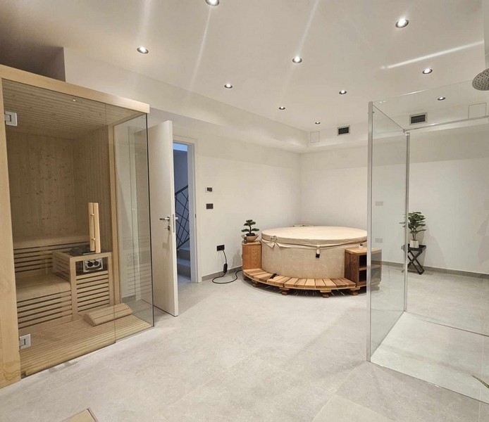 Velké wellness centrum s jacuzzi, saunou a sprchou.