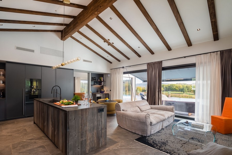 Otevřený obývací prostor s kuchyní a odhalenými trámy