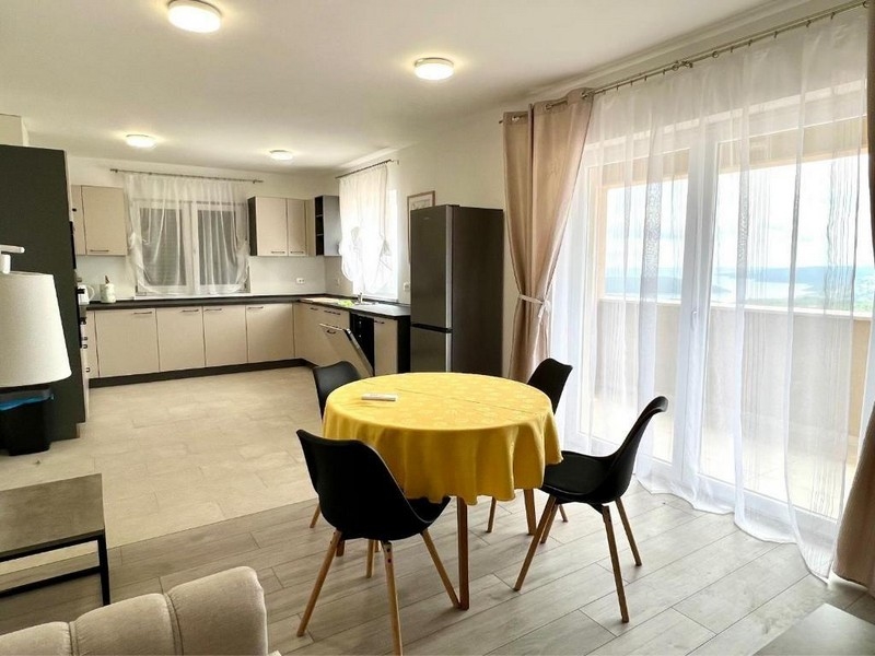 Světlý jídelní kout s kuchyní a vstupem na terasu