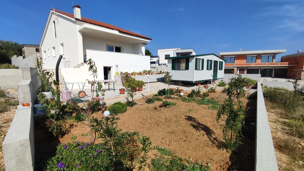 Udržovaná zahrada a hospodářské budovy rodinného domu na prodej ve Vodicích, Chorvatsko.