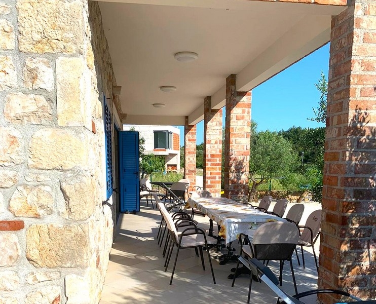 Krytá venkovní jídelna kamenného domu na prodej v Chorvatsku, ideální pro setkání.