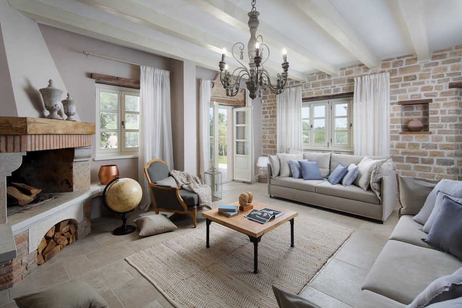 Útulný obývací pokoj s krbem, pohodlnými pohovkami a přirozeným světlem procházejícím závěsy - Real Estate Croatia