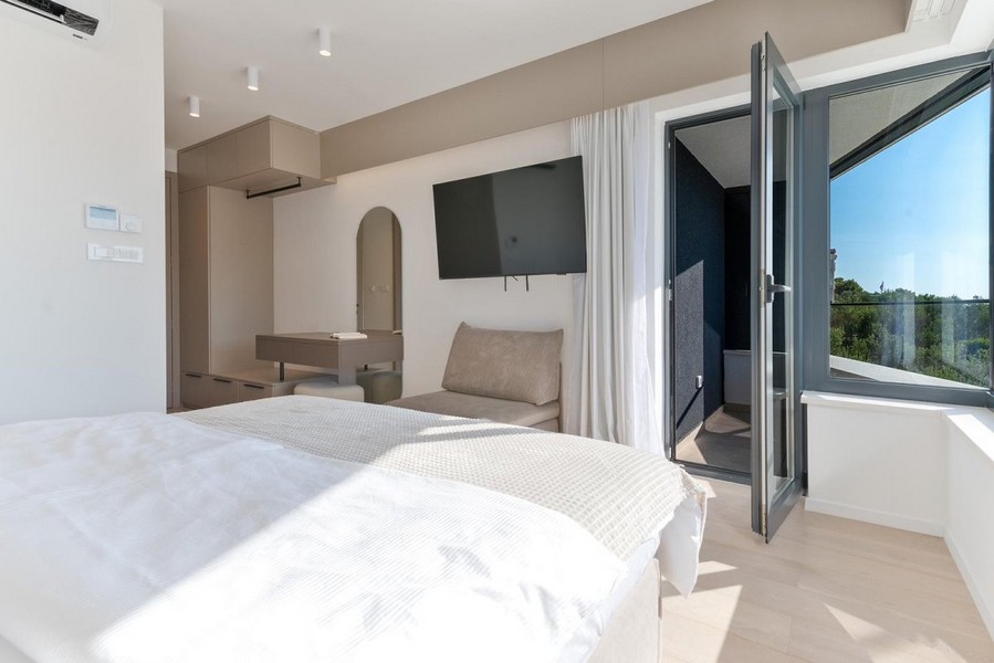 Ložnice v chorvatské vile na prodej s moderním designem a přístupem na balkon.