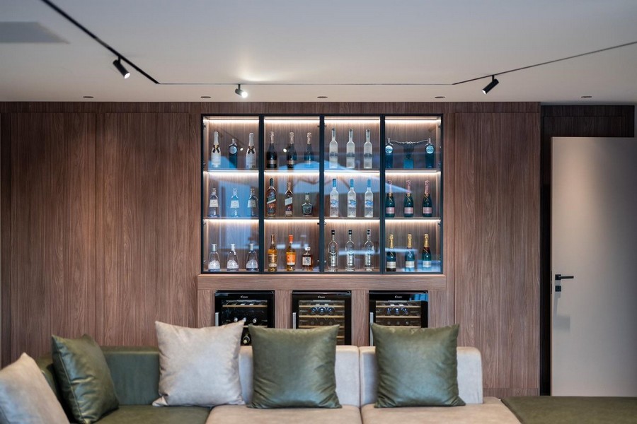 Elegantní domácí bar v luxusní vile na prodej v Chorvatsku s dřevěným obložením a osvětlením.