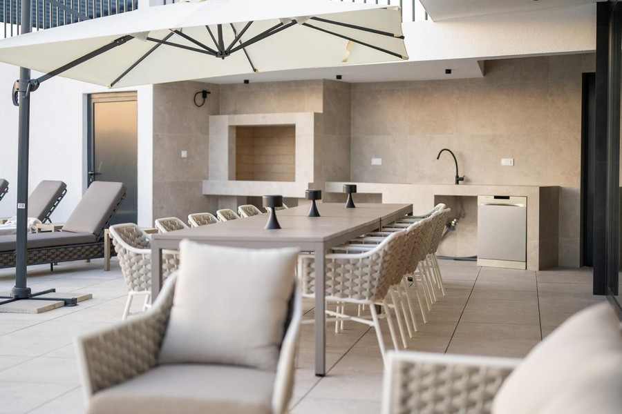 Terasa vily na prodej v Chorvatsku s jídelním koutem a ochranou proti slunci.