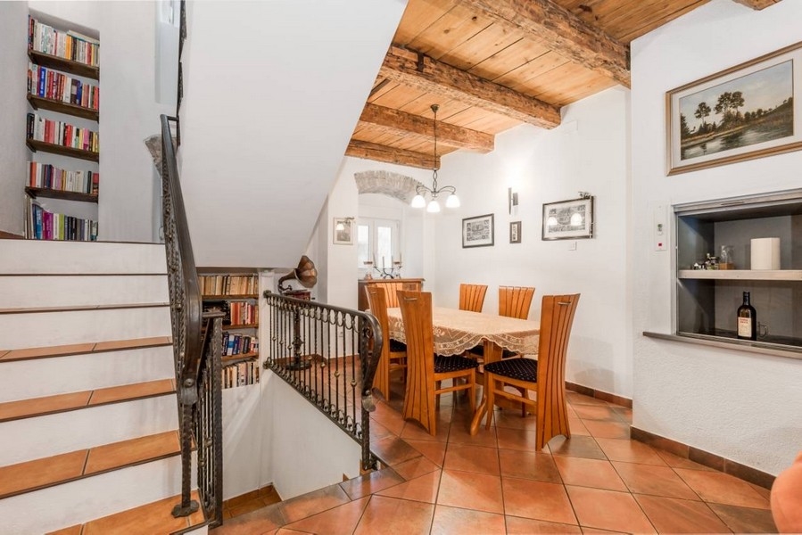 Jídelna v interiéru chorvatské nemovitosti s dřevěnými trámy a schody