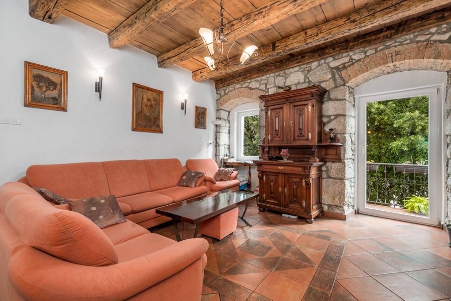 Obývací pokoj nemovitosti v Chorvatsku se zděným obloukem a přístupem na balkon