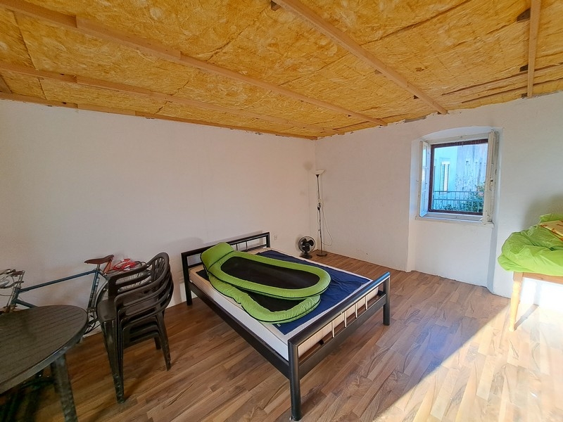 Světlá ložnice s dřevěným stropem a minimalistickým dekorem v nemovitosti v Chorvatsku, dostupná prostřednictvím Panorama Scouting.