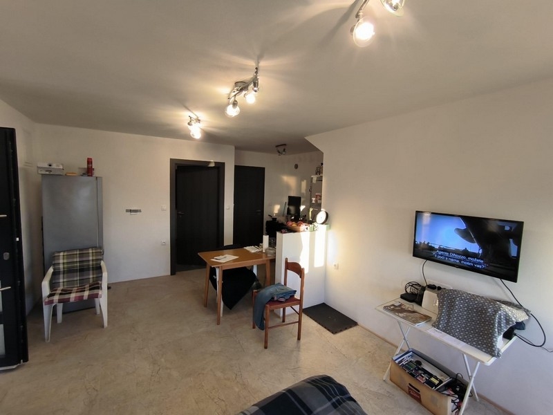 Jiný pohled na obytný prostor v nemovitosti v Chorvatsku, s výhledem na vstupní dveře a televizi