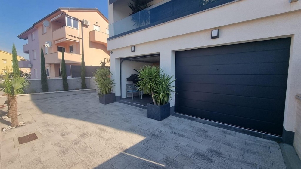 Předzahrádka moderního chorvatského pozemku s garážovými vraty