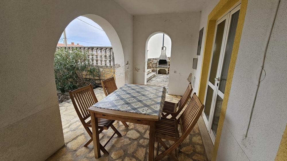 Zastřešená venkovní terasa s jídelním stolem v domě na prodej v Karlobagu