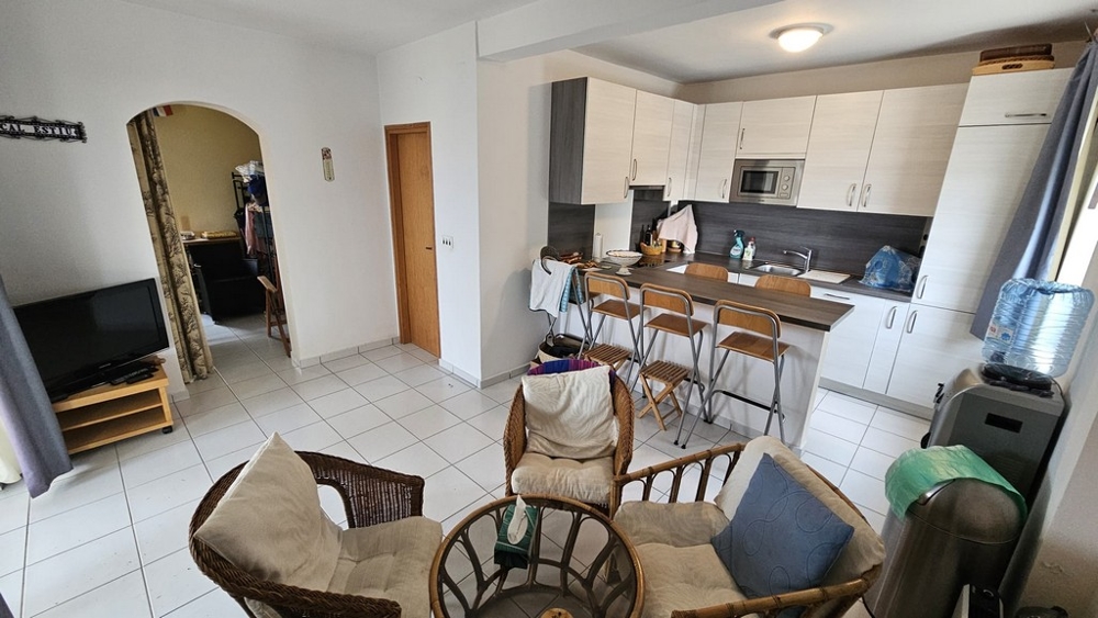 Vnitřní pohled na obývací pokoj s kuchyní v domě na prodej v Karlobagu