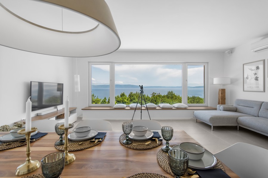 Moderní obývací pokoj s panoramatickým výhledem z okna na Jaderské moře na Istrii, realitní agent Panorama Scouting