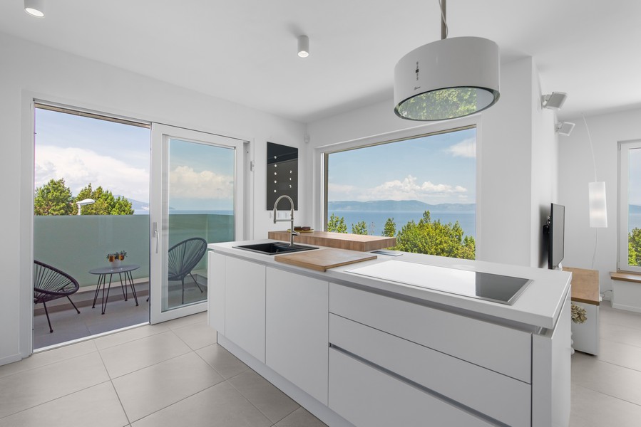 Světlá kuchyně s moderním nábytkem a výhledem na moře ve vile na Istrii, kterou nabízí Panorama Scouting