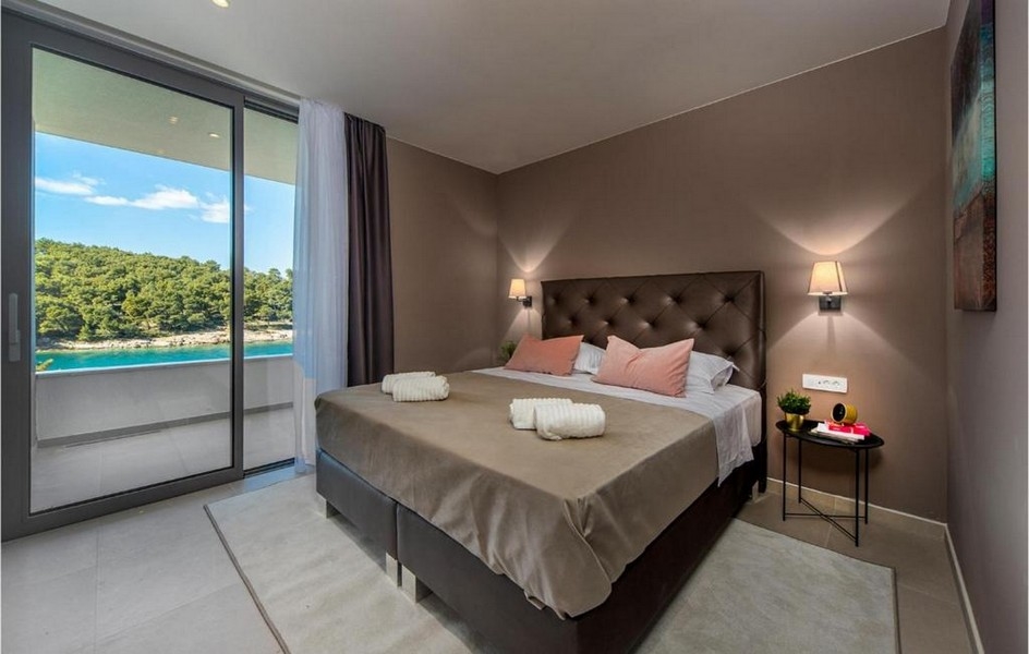 Ložnice s manželskou postelí, moderní design a výhled na moře ve vile na Brači.