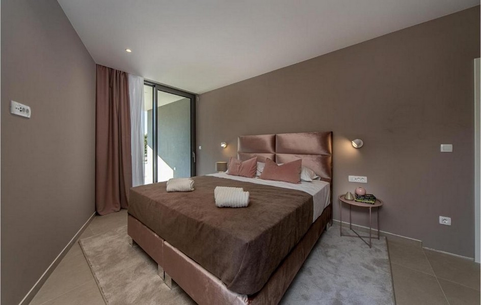 Elegantní ložnice se vstupem na terasu v luxusní vile na ostrově Brač.