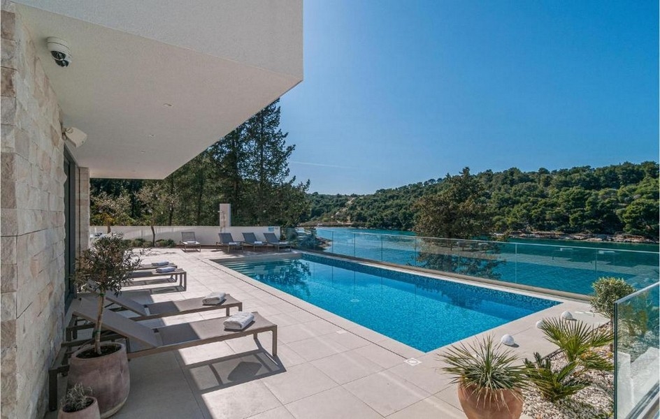 Terasa u bazénu s výhledem na klidnou zátoku na ostrově Brač, Chorvatsko