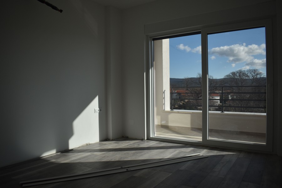 Prázdný pokoj s přístupem na balkon a výhledem na moře v moderní vile na Krku.