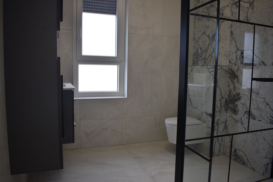 Moderní koupelna s mramorovými obklady a toaletou ve vile na prodej na ostrově Krk v Chorvatsku.